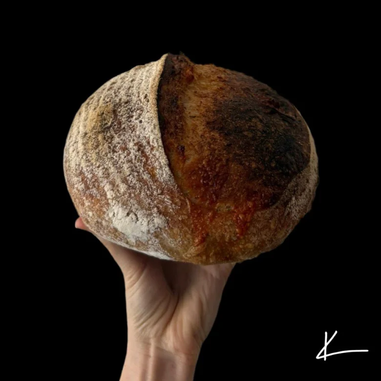 Domácí chléb s křupavou kůrou v ruce