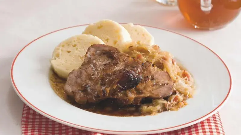 Kysané zelí s masem a knedlíky na talíři