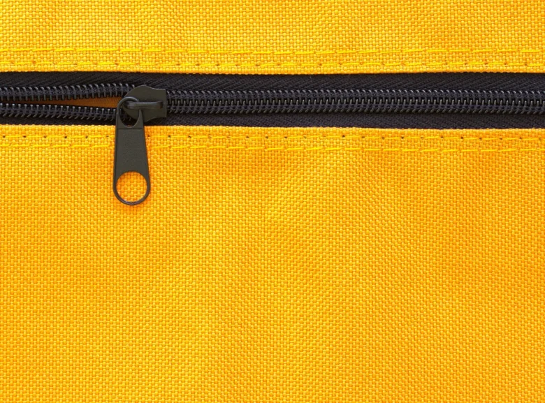 Detail černého zipu na žlutém textilním materiálu