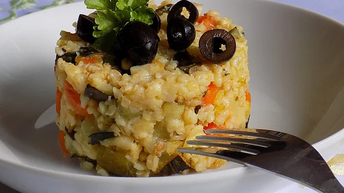 Bulgur se zeleninou na talíři s olivami a petrželí