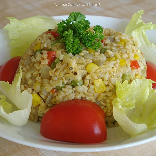 Bulgur se zeleninou na talíři s rajčaty a salátem