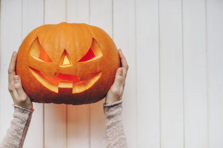 Vyrobený dýňový svíčka s vyřezaným tváří na Halloween.