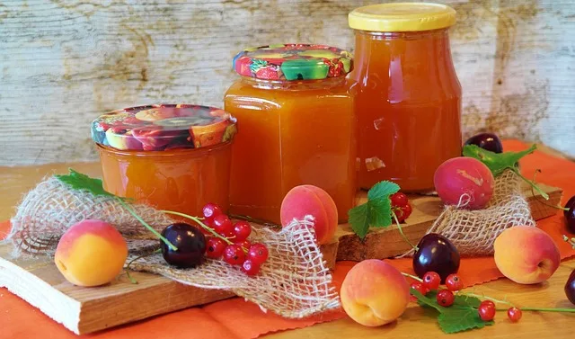Domácí meruňková marmeláda v skleničkách s čerstvými ovocem