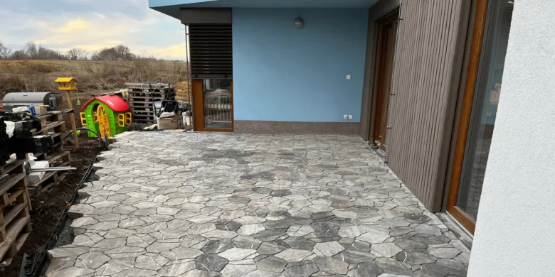 Dokončená terasa z kamenných dlaždic u domu