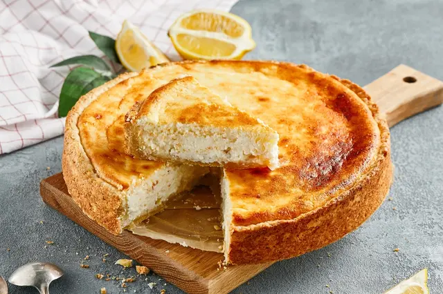 Zlatohnědá tarta s ricottou na dřevěném podnosu.