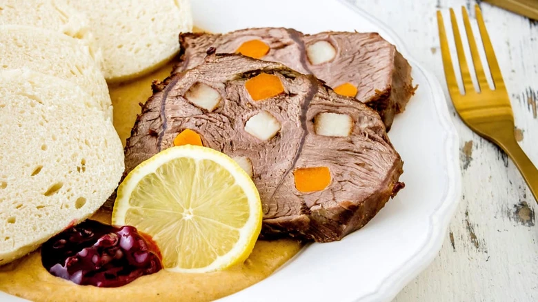 Tradiční české pečeně s bramborami a citronem na talíři