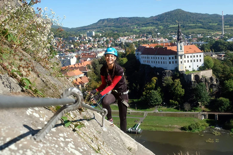 Žena na železné cestě s výhledem do českého města