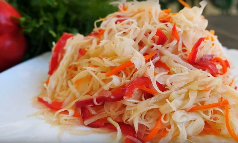 Fermentovaná zelenina s červenou paprikou na bílém talíři