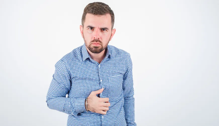 Muž s bolestí v břiše, drží se za břicho