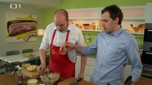 Muži připravují rumcajs salát v kuchyni s ingrediencemi.