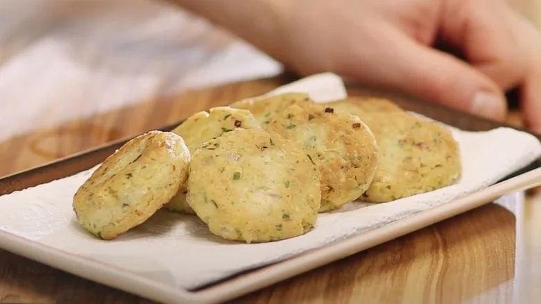Zlatohnědé falafele na bílém talíři s papírovou utěrkou.