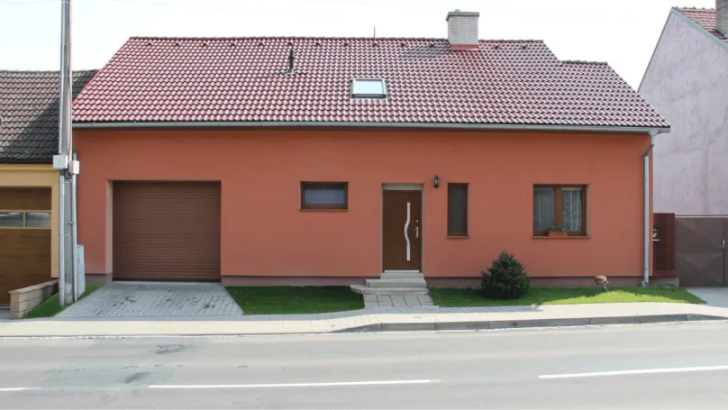 Rekonstruovaný rodinný dům s oranžovou fasádou a garáží