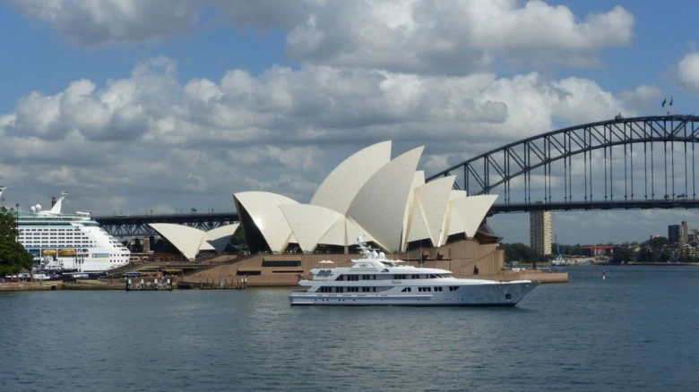 Sydney Opera House s mostem a jachtem v přístavu