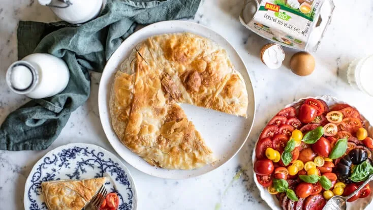 Balkánský burek s čerstvými ingrediencemi na bílém podkladu