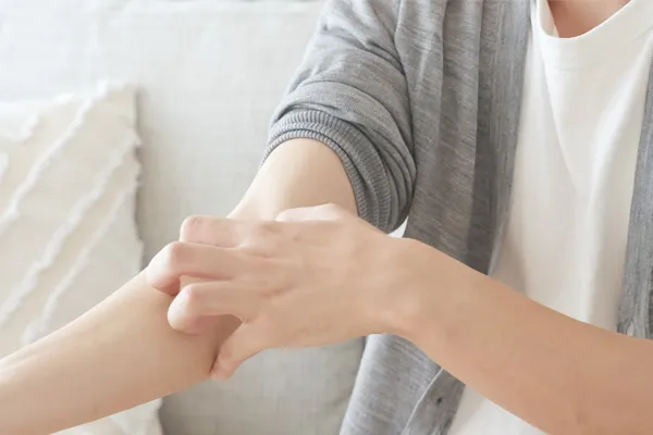 Osoba si škrábe paži kvůli svědění kůže
