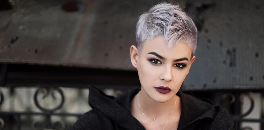 Žena s krátkými šedými vlasy a tmavým make-upem