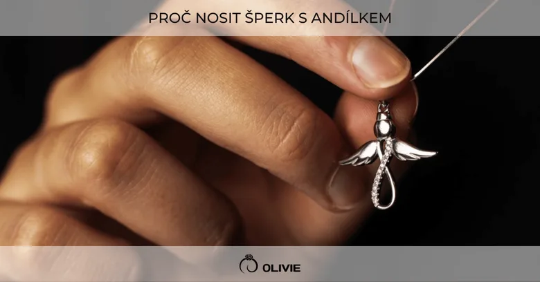 Ruka drží stříbrný šperk s andělem na řetízku.