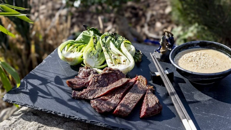 Grilovaný pak choi s hovězím masem a omáčkou na šedém podkladu
