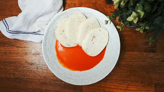 Bílý talíř s rajčatovou omáčkou a plochými chlebíčky