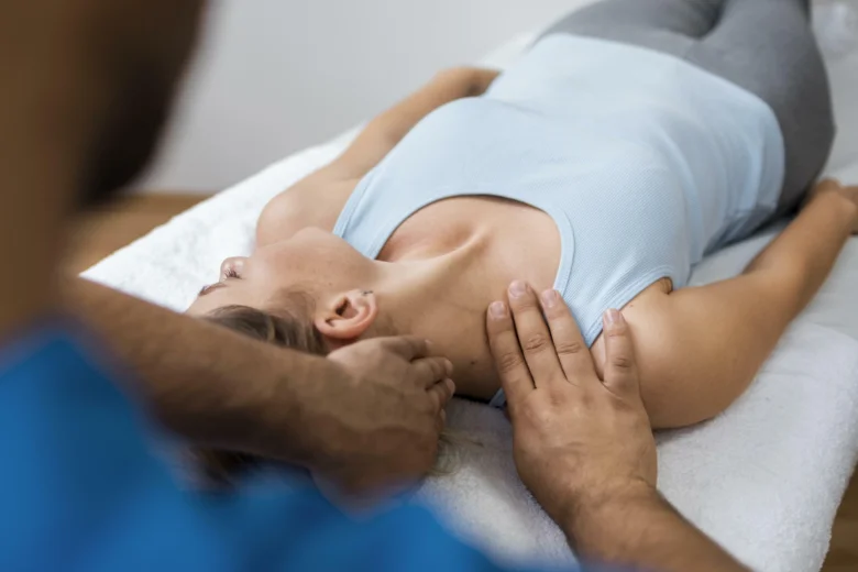 Terapeut masíruje krční páteř pacientce ležící na zádech
