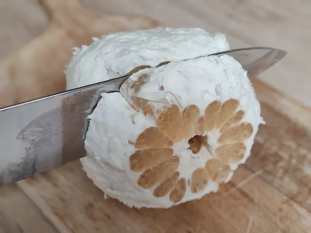 Nož řeže pomelový plod, odhaluje segmenty