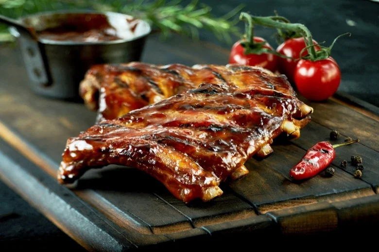 Pečená žebra s omáčkou, rajčaty a chilli papričkou.