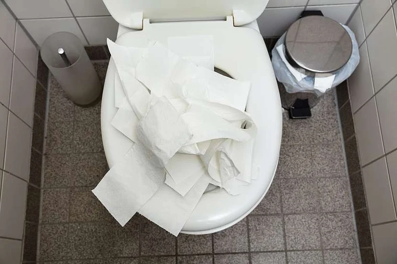 Zapchaný záchod s přehnaným množstvím toaletního papíru.
